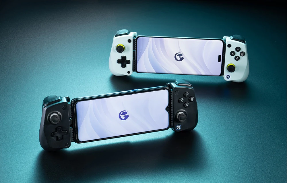 Două controlere GameSir cu smartphone-uri atașate - unul alb și unul negru - așezate pe o suprafață albastră.
