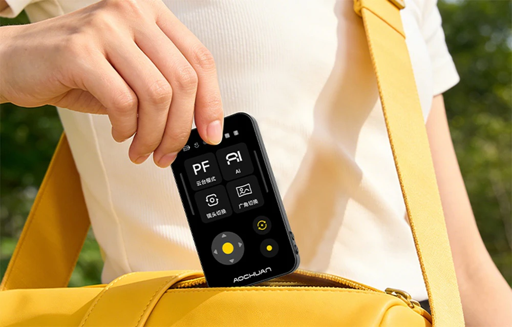 Modul negru cu ecran LCD pentru gimbalul Aochuan Smart X Pro scos dintr-o borsetă galbenă