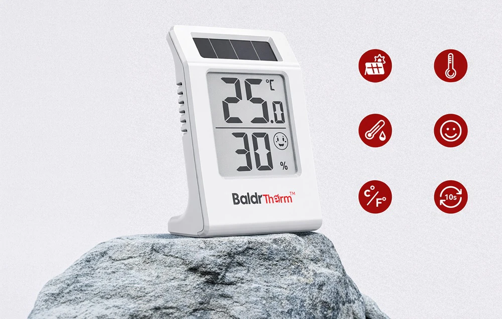 Termohigrometrul Baldtherm pe o scală, pe un fundal deschis, lângă o pictogramă care ilustrează funcțiile dispozitivului
