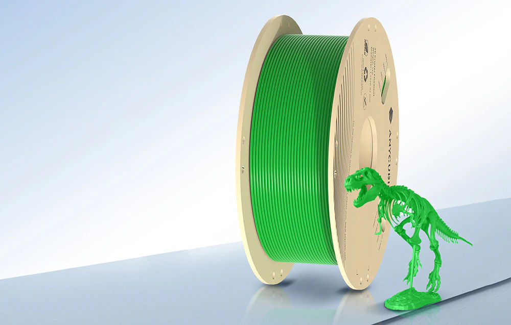 Filament verde cu model imprimat 3D pe masă albastră.