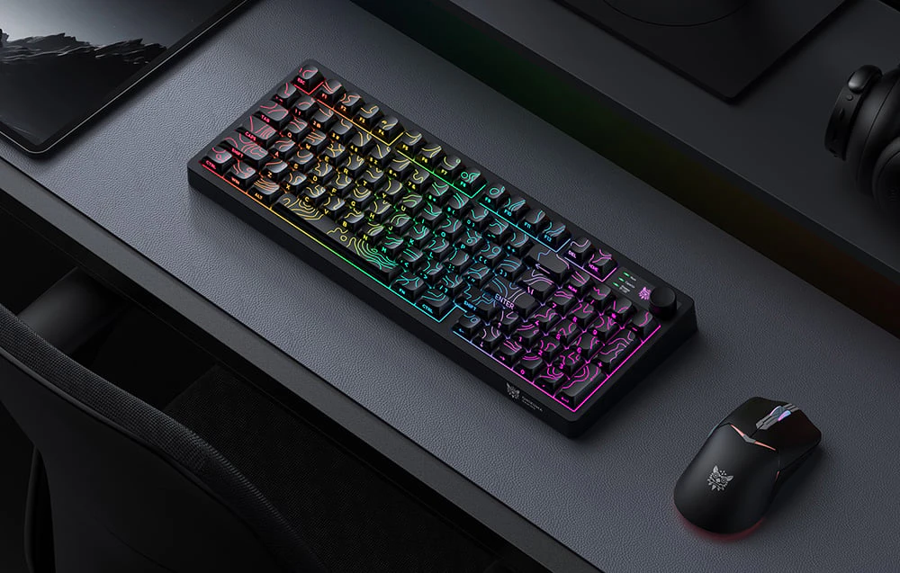 Tastatură și mouse de gaming pe un birou negru cu un mouse pad negru.