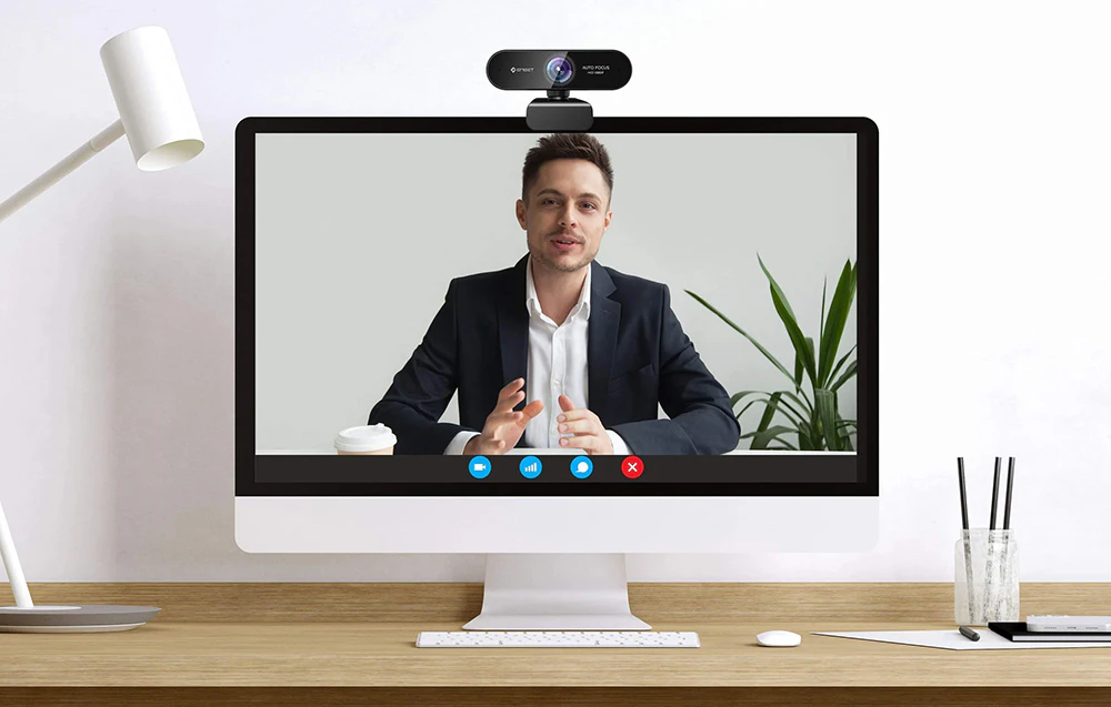 Un monitor de computer cu o cameră web montată, care afișează un bărbat în timpul unei videoconferințe.
