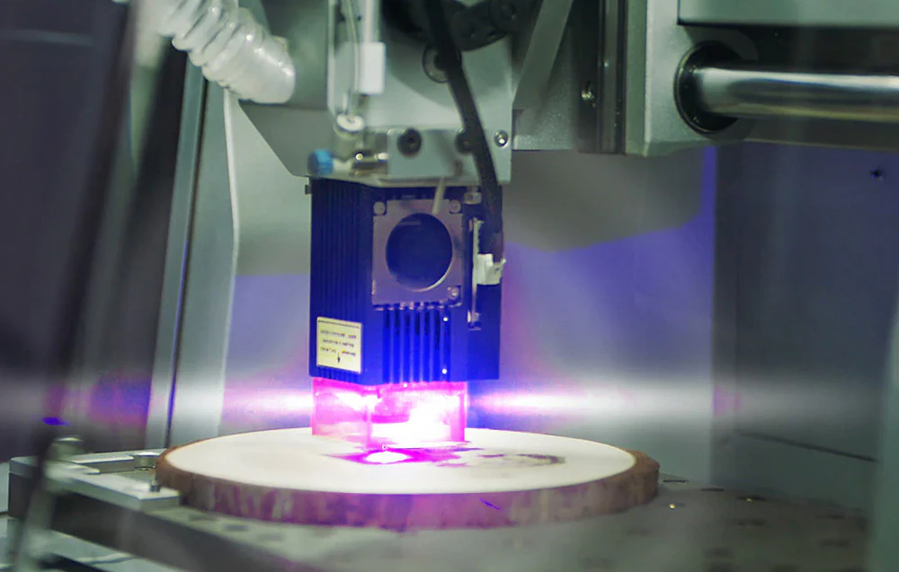 Modul laser într-un router CNC desenând un model pe lemn