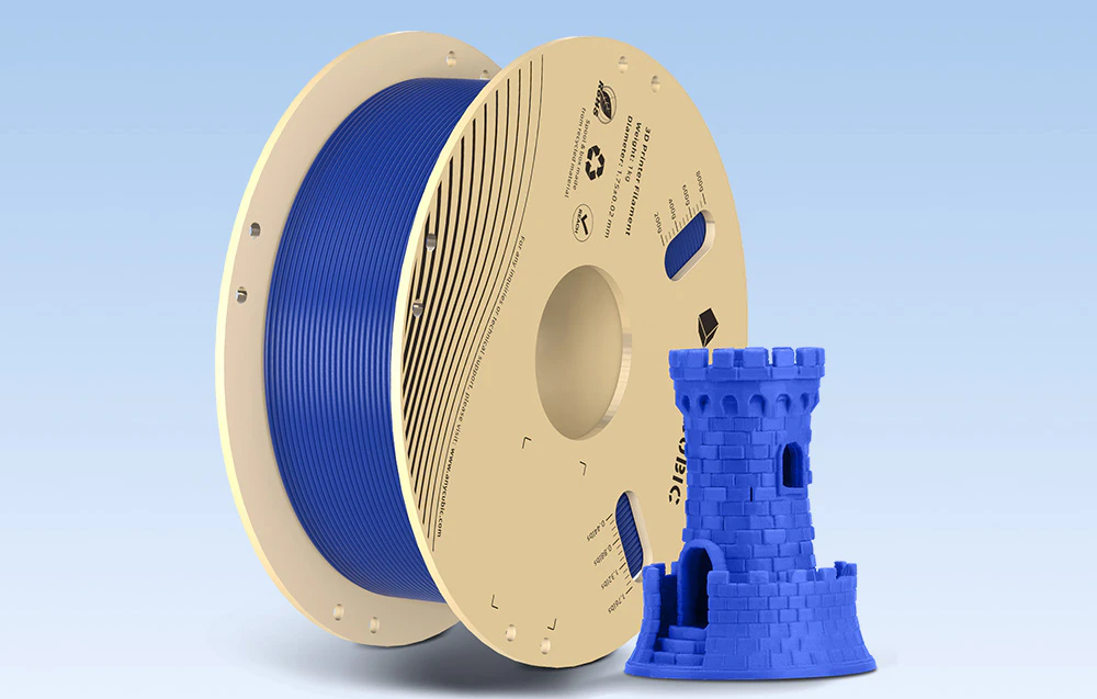 Filament albastru lângă fogura 3D imprimată pe un fundal albastru.