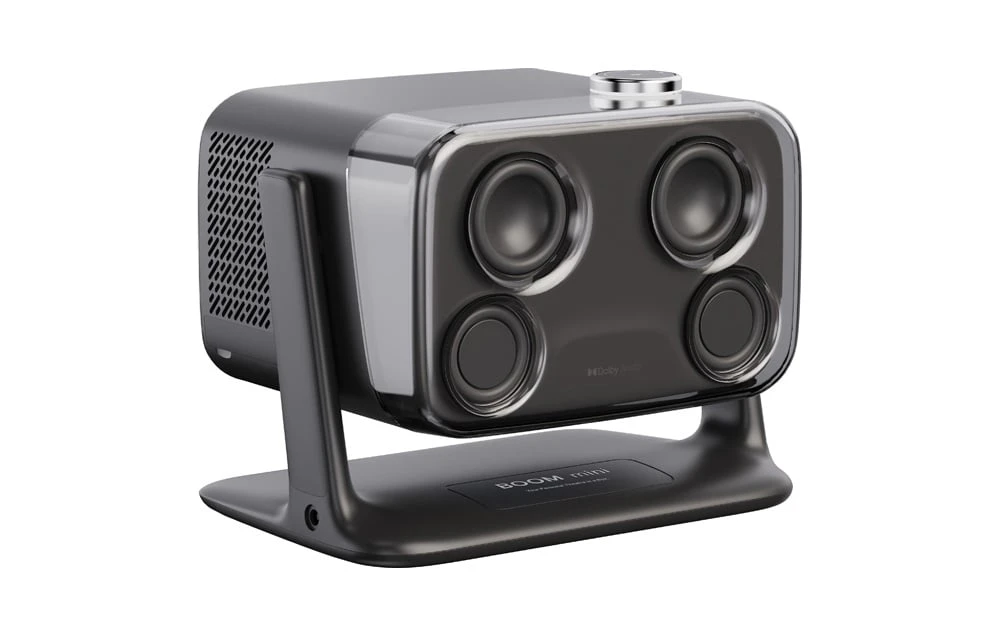 Partea din spate a proiectorului cu inscripțiile „BOOM mini” și „Dolby Audio”, prezentând patru difuzoare sub o carcasă transparentă