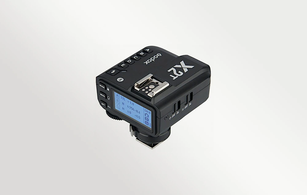 Declanșatorul radio Godox X2T negru, prezentat dintr-un unghi, cu ecranul LCD iluminat din spate
