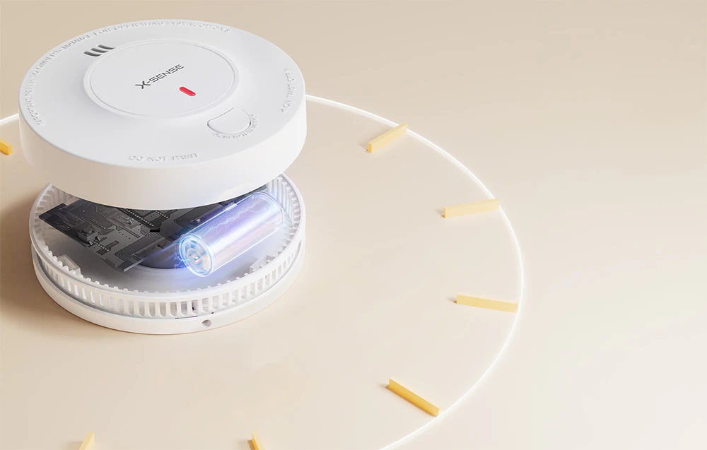Detector de fum X-Sense deschis, cu bateria și placa de circuit vizibile
