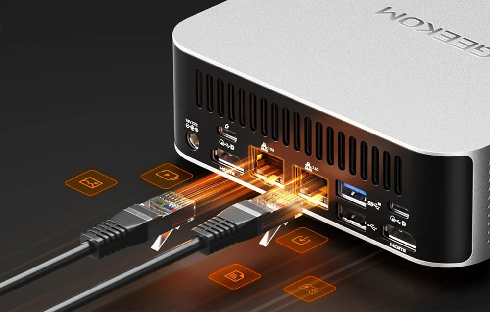 close-up al porturilor unui computer Geekom la care sunt conectate cabluri