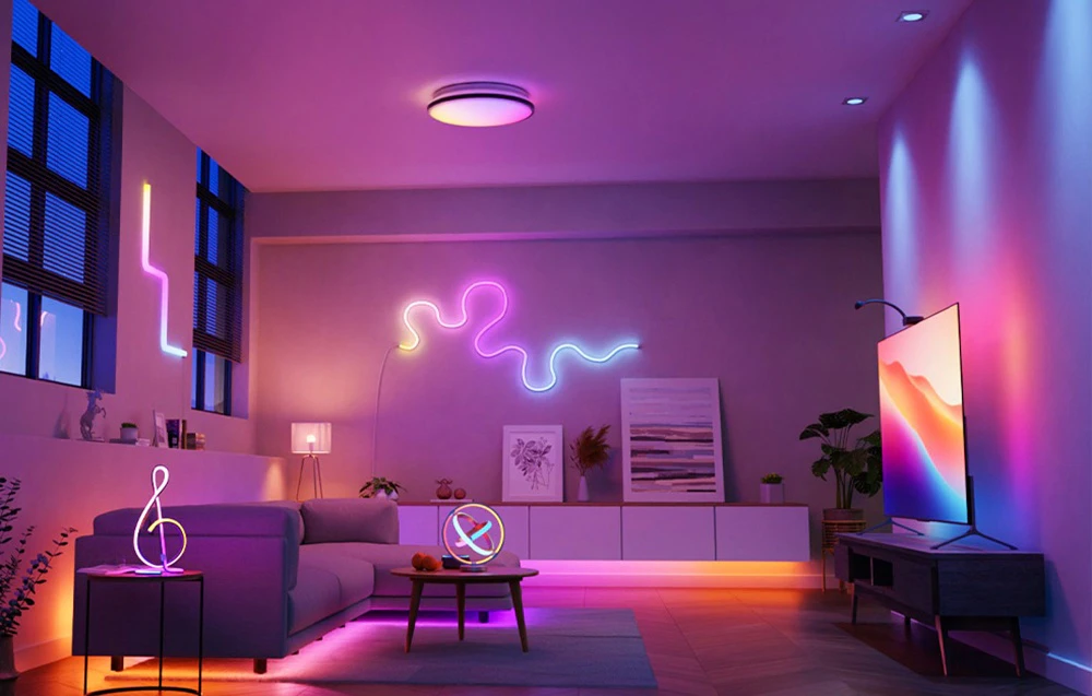 O cameră cu canapea și televizor, iluminată colorat cu benzi LED